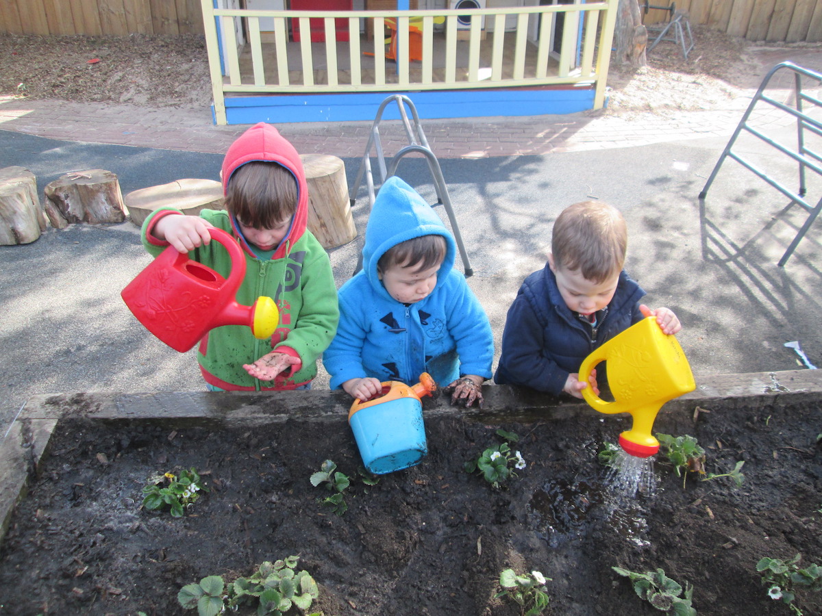 Three children watering the garden