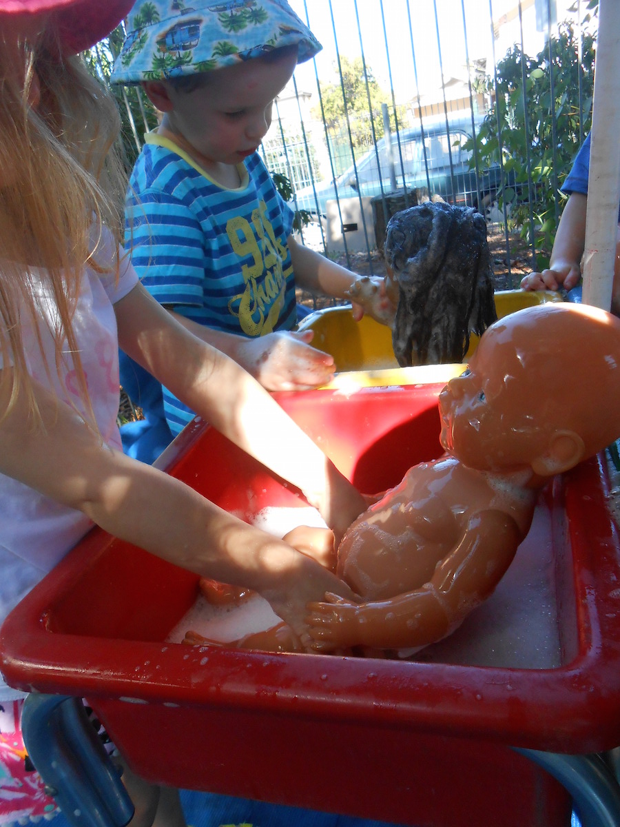 Toddlers bathing baby dolls